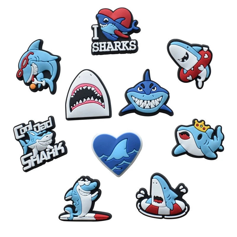 A collection of decorative shoe charms and pins featuring shark designs in various colors and styles.