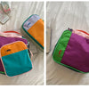 A set of colorful waterproof travel toiletry bags in green, purple, and orange nylon construction.