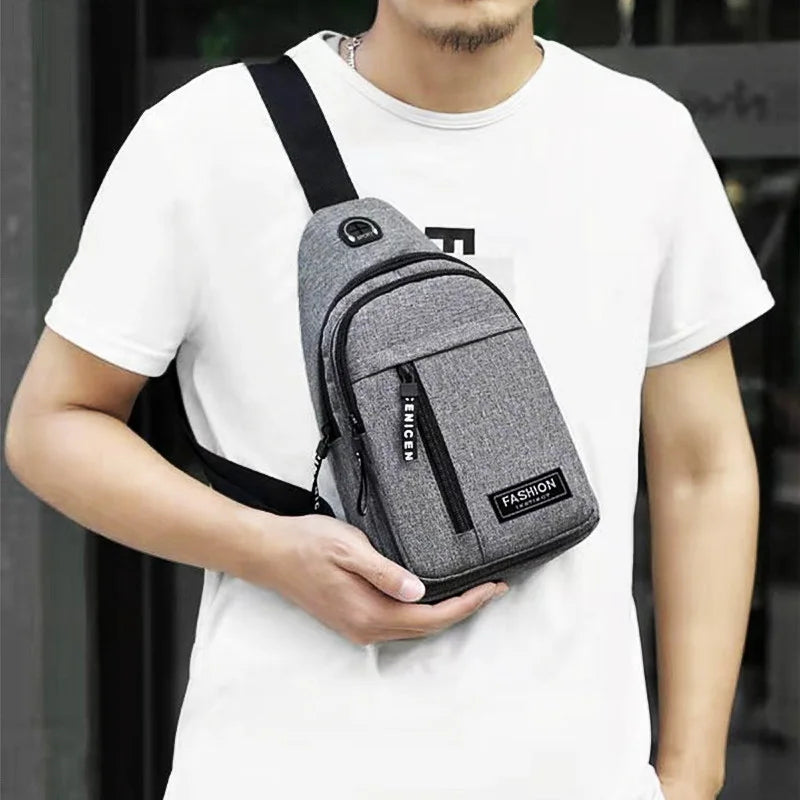 A person wearing a white t-shirt holds a gray water-resistant casual chest bag with a phone pocket.