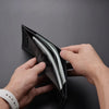A hand is opening a black men's PU leather folding wallet to show the contents.