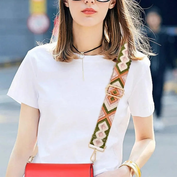 A woman models a white t-shirt and a red bag with an adjustable nylon strap.