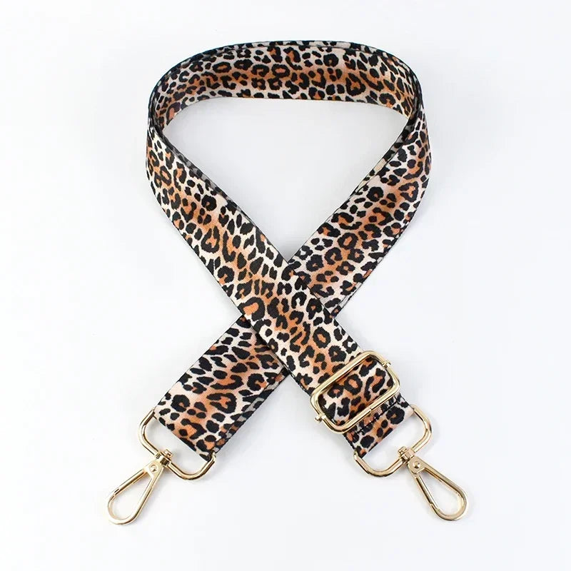A leopard print adjustable crossbody strap made of brown and black animal print leather.