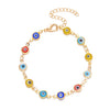 A gold chain bracelet featuring blue evil eye charms.