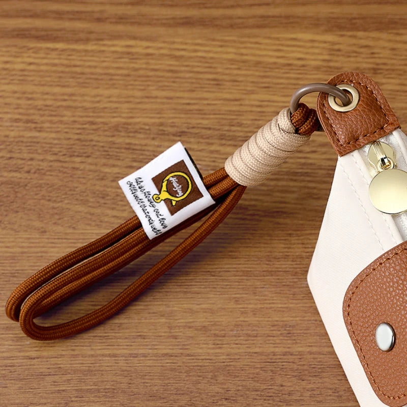 Brauer Lederarmband und Münztasche mit goldfarbener Schnalle auf Holzoberfläche.