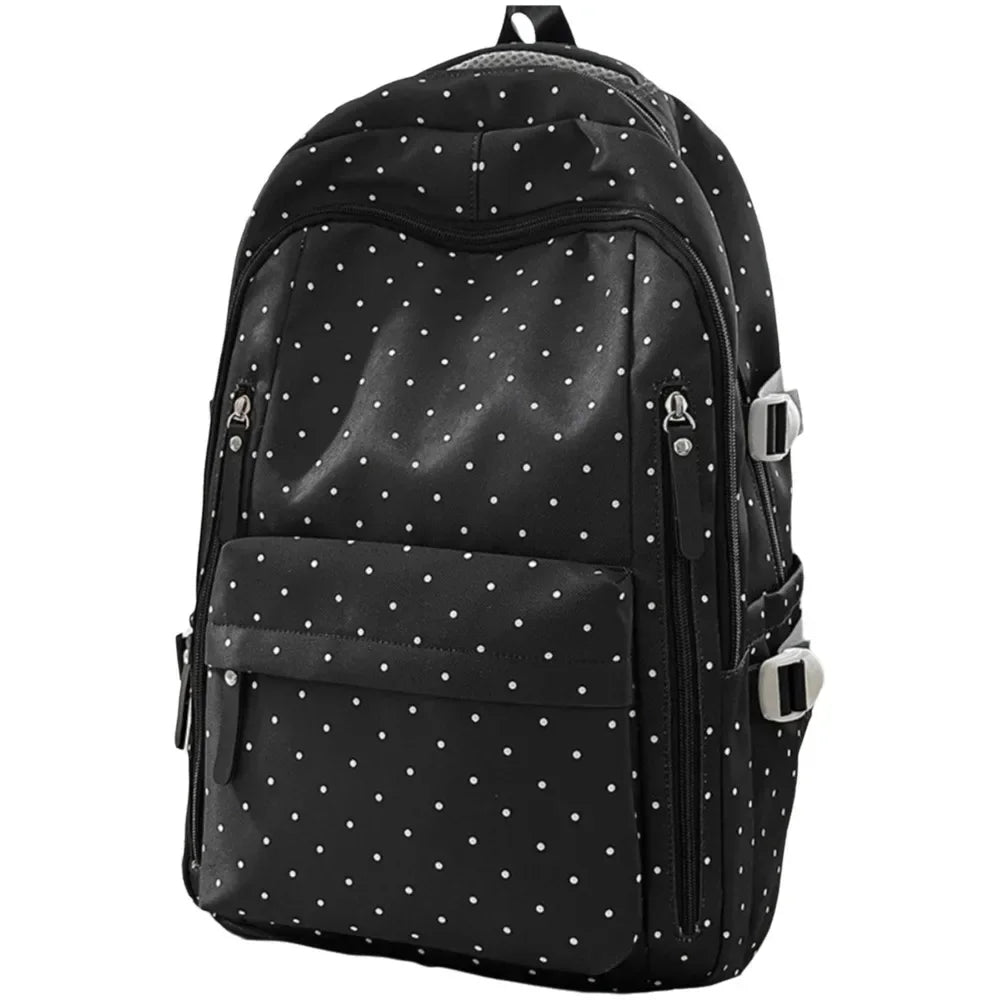Black corduroy backpack with a white polka dot pattern and silver hardware