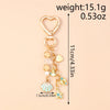 Gold heart-shaped keychain featuring a seashell and starfish charm with pearl accents