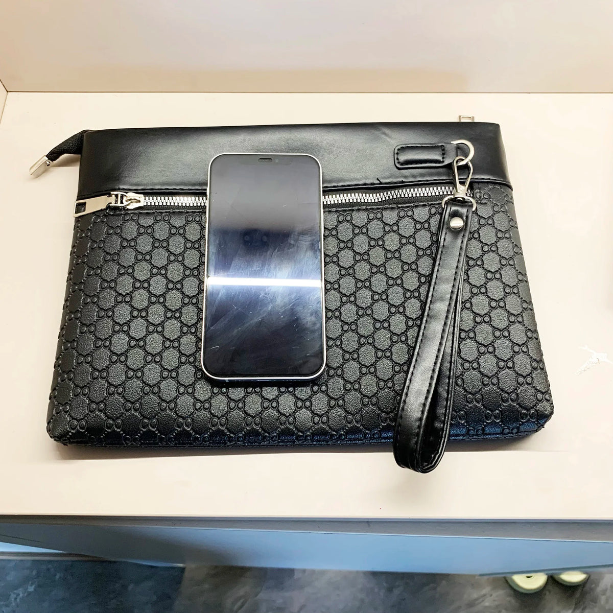 A black PU leather clutch bag with a crocodile pattern is shown open, displaying a smartphone slot.