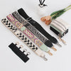 A collection of black and patterned phone lanyards with detachable leather wallets and a white cylindrical object.