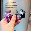 A hand holds a shiny, metallic purple and pink balloon dog keychain charm against a blurred background.