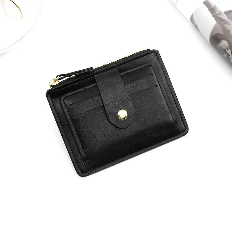 Black leather card holder wallet with a coin pocket shown on a white surface.