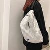 Ein weiß kariertes modisches Brusttasche wird an einem schwarzen Kleid getragen.