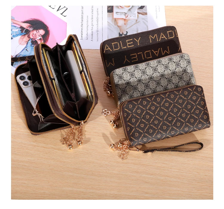 Cartera con cremallera de cuero sintético marrón, manga estampada y detalles de cadena dorada.