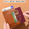 Portefeuille de voyage fin marron contenant un passeport et d'autres documents.