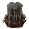 Mochila de senderismo gris de lona con detalles en cuero marrón y correas ajustables.