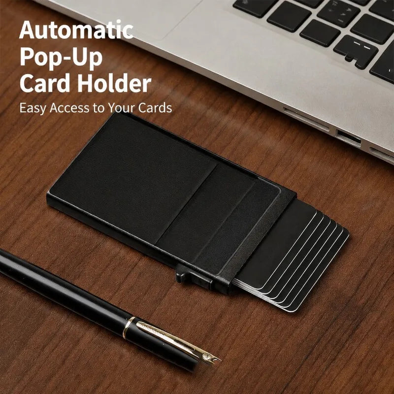 Porte-cartes pop-up en métal noir à côté d'un ordinateur portable et d'un stylo sur une surface en bois.