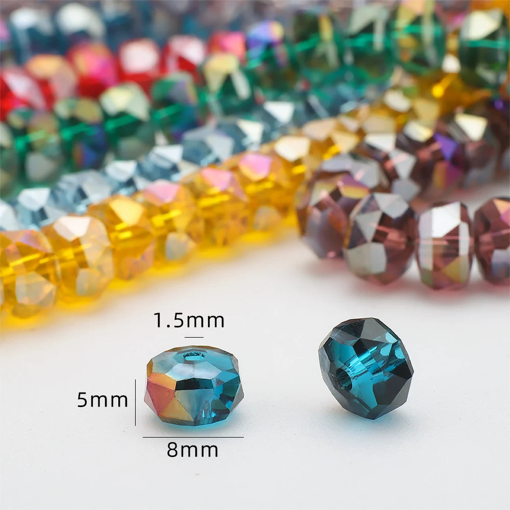 A close-up of faceted blue crystal glass beads in various colors and shapes, including a 5x8mm wheel shape.