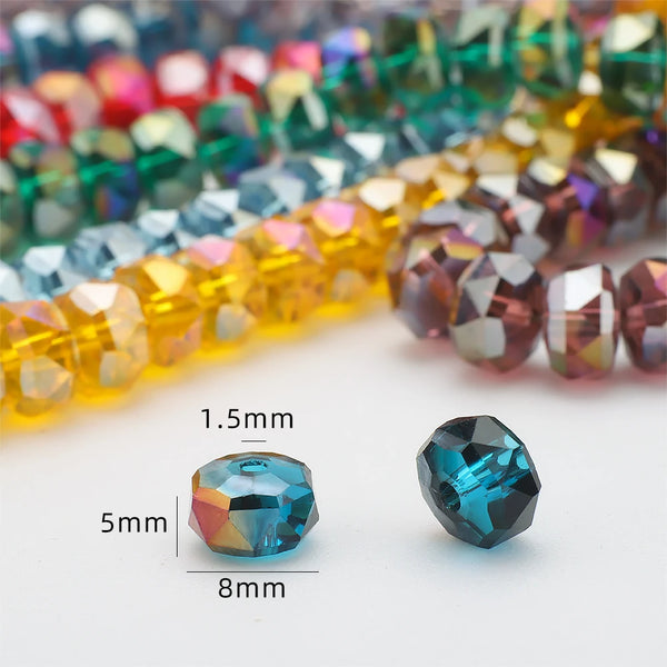 A close-up of faceted blue crystal glass beads in various colors and shapes, including a 5x8mm wheel shape.