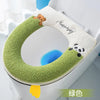 A green plush waterproof toilet seat cover with a bear and panda design is shown in a white toilet bowl.