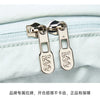 Gold-toned luggage tags attached to a light blue fabric, used for securing the lightweight waterproof daypack.