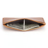 A brown genuine leather card holder with a slot displaying US dollar bills.