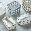 A collection of waterproof cotton linen storage baskets with various patterns and colors arranged on a light gray surface.
