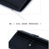 Close-up detail of a black genuine cow leather bifold wallet showing the oil edge process and hardware button.