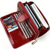 A maroon leather long wallet with a wrist strap, showing multiple cards and cash inside.
