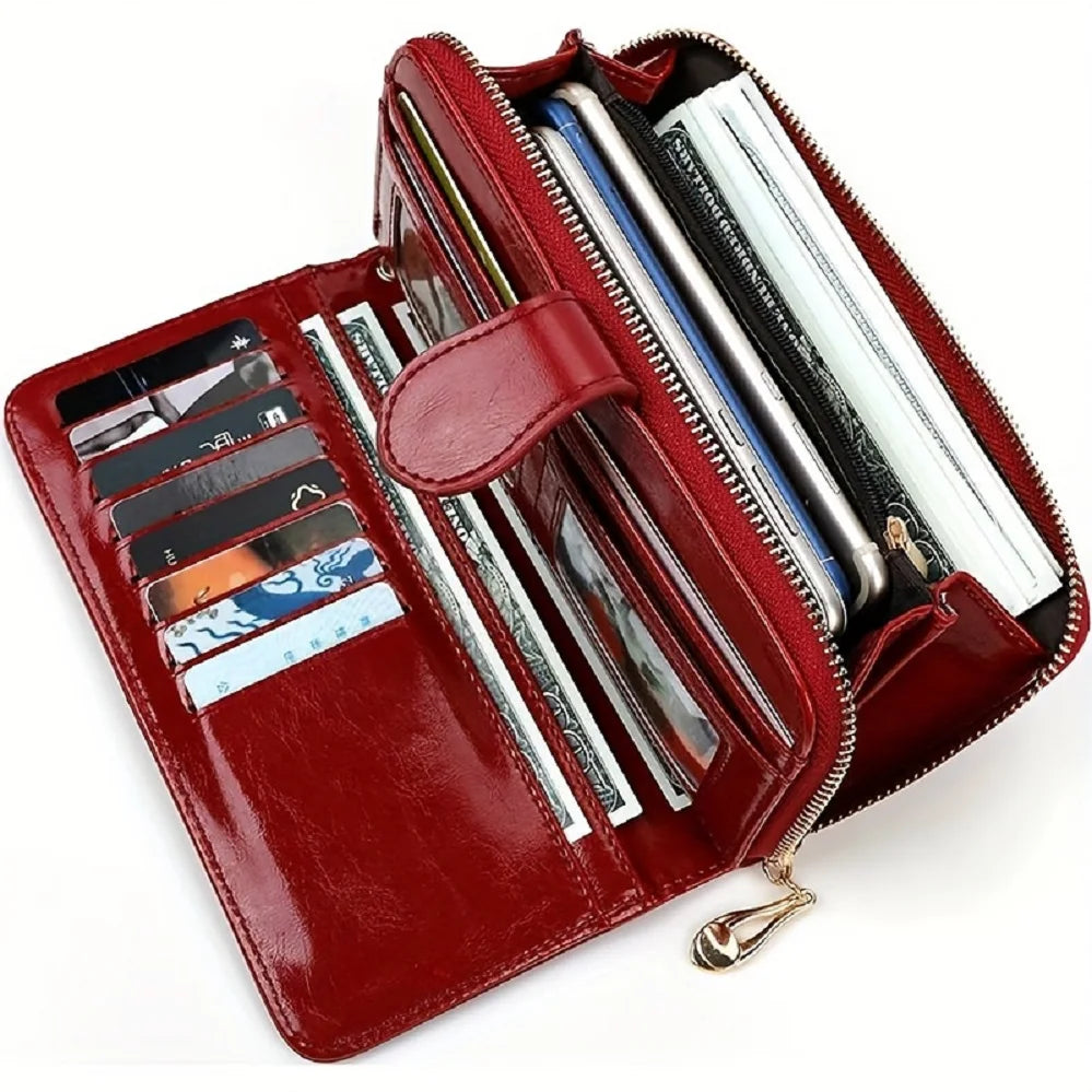 A maroon leather long wallet with a wrist strap, showing multiple cards and cash inside.