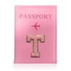 A pink leather passport holder with a gold initial T and a pink airplane emblem.