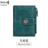 A teal leather multi-fold wallet with stitching and a decorative embossed circle detail.
