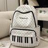 Sac à dos blanc à pois noirs et bordure noire, avec un motif de note musicale.