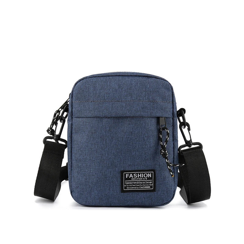 A dark blue minimalist nylon crossbody bag for men with black strap and hardware.