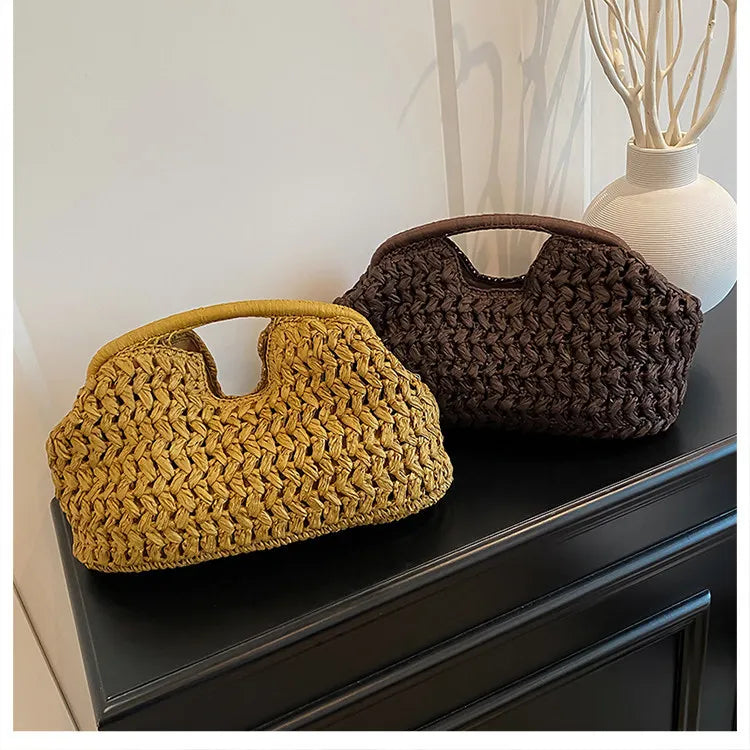 A close-up of a straw woven tote handbag in yellow and dark brown colors resting on a dark cabinet.
