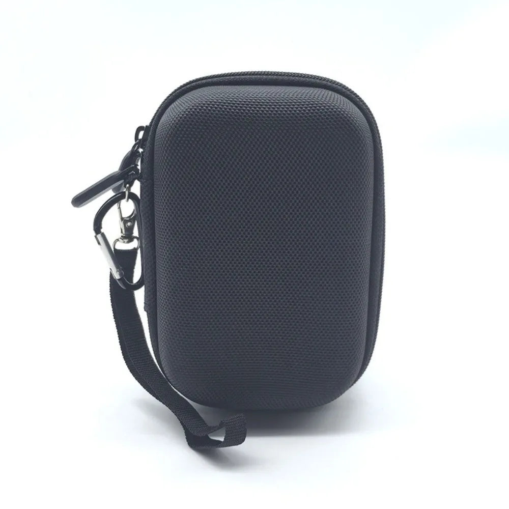 Black durable hard shell case for a digital camera with a strap and attached key ring.