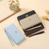A stack of multi-functional zipper wallets in black, gray, and light blue leather textures next to a vintage alarm clock.