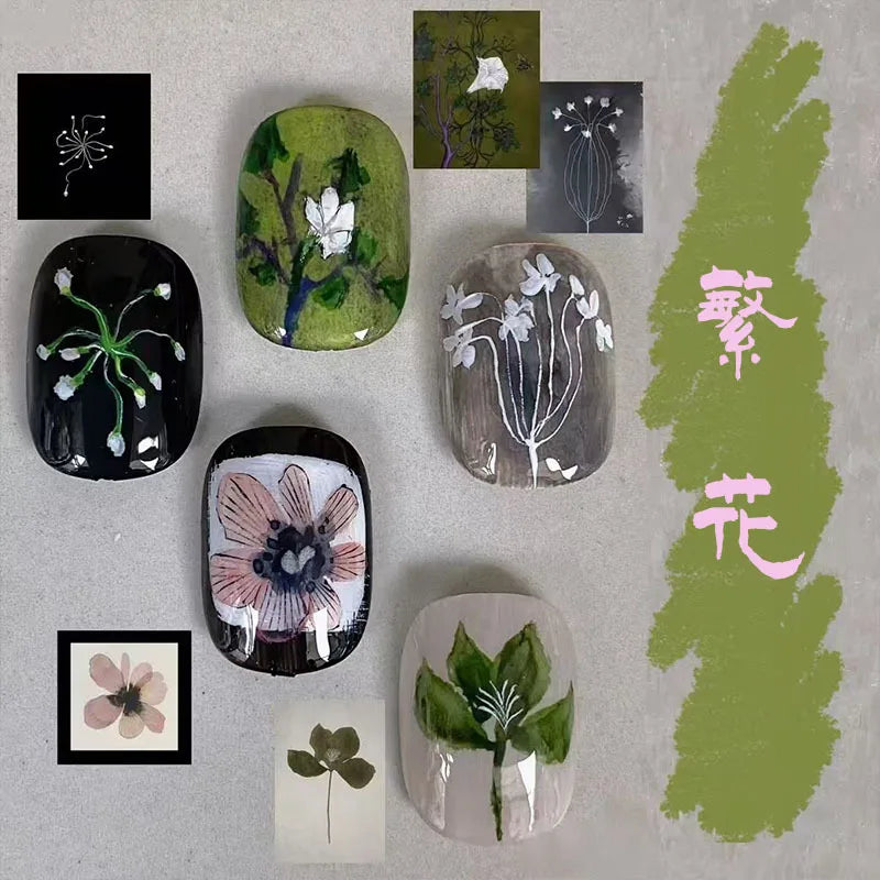 A collection of cute cartoon press-on nails in various shades of green and natural tones displayed on a light surface.