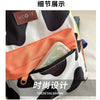 Close-up detail of a white and black cow print fashion backpack showing the interior lining and a leather tag.