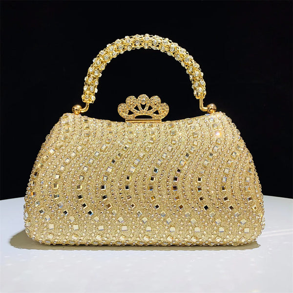 A gold crystal-embellished evening clutch bag with a chain strap resting on a white surface.