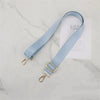 Light blue adjustable nylon shoulder strap with gold hardware displayed on a white card.