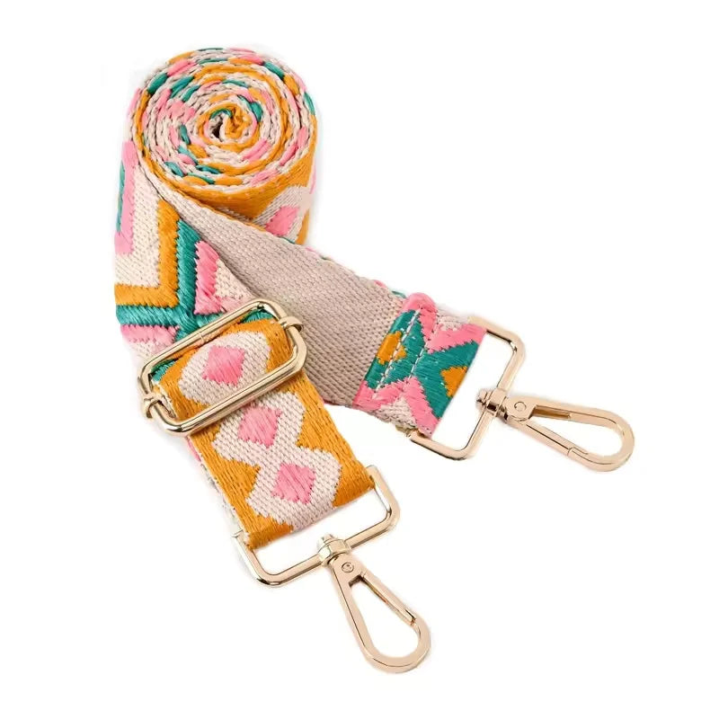 A rolled adjustable nylon crossbody bag strap featuring multicolored geometric patterns.