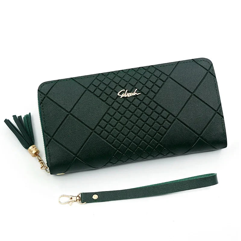 A dark green quilted clutch wallet with gold accents and a matching leather strap.