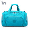 A teal nylon travel duffle bag with zippered compartments and handles.