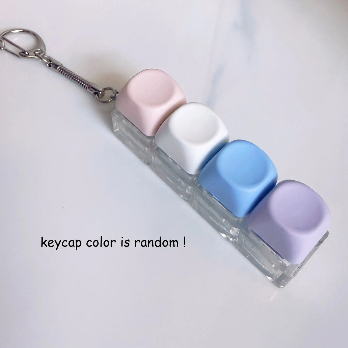 Cléportefeuille acrylique transparent avec des clés de macaron colorées et une chaîne argentée.