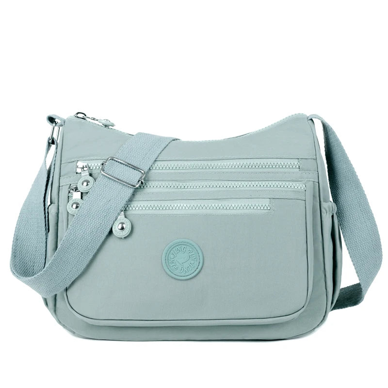 A light gray waterproof nylon crossbody shoulder bag with a zipper and strap.