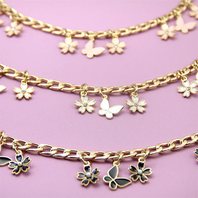 Gold chain necklace with white flower charms and black butterfly charms