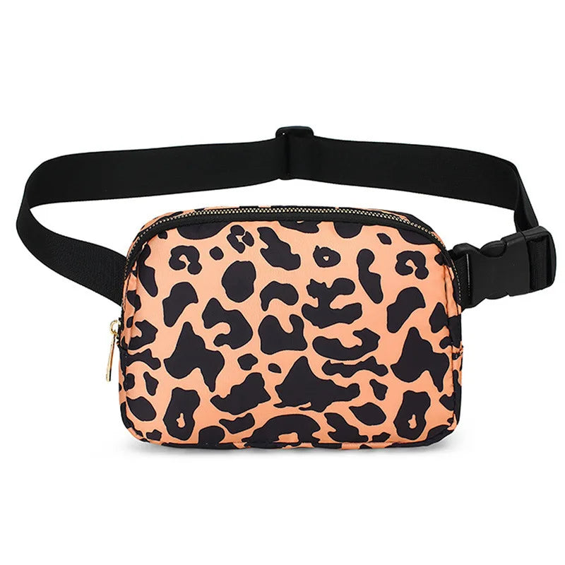 A tan leopard print waist bag with a black strap is shown against a white background.