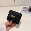 A black multi-slot card holder is held in a hand on a white surface.