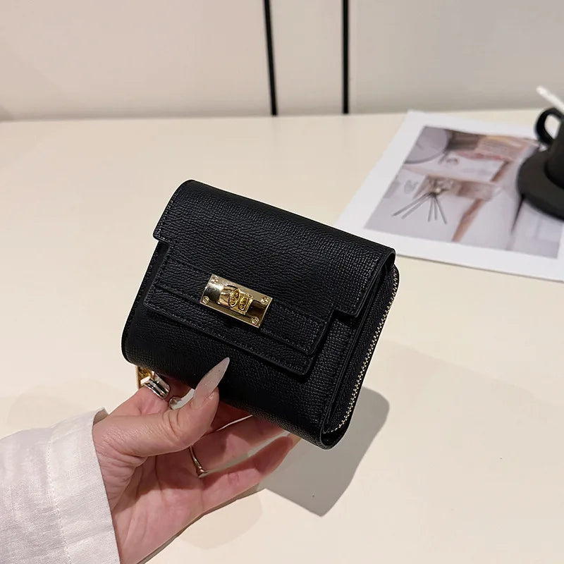 A black multi-slot card holder is held in a hand on a white surface.