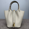 A light beige classic genuine leather bucket bag with a smooth texture and gold-toned hardware.
