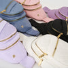 Collection de sacs bandoulière rembourrés et façon sling dans diverses nuances de violet, rose, bleu et noir.